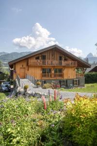 a large wooden house with a garden in front of it at Appartement Chez Francois in Morillon