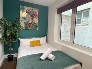 a bedroom with a bed with a painting on the wall at Super Central Big House 6 Bedroom House I Next to Brighton Beach in Brighton & Hove