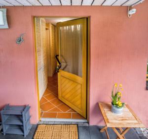 a door to a pink house with a table at Behagliche Ferienwohnung im Siebengebirge in Königswinter