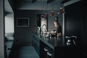 a woman sitting at a counter in a kitchen at Svart Lodge in Akureyri