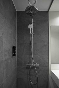 La salle de bains est pourvue d'une douche avec un pommeau de douche. dans l'établissement Zleep Hotel Horsens, à Horsens