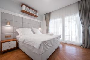 a bedroom with a large white bed and windows at SunRise Beach in Venus