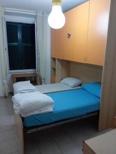 two beds in a small room with a light at Brezza Marina 3021 in Genova +11 photos