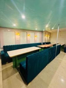 Una habitación con asientos y mesas azules en un tren. en Olive Ventures, Royal inn, Ritz, en Srinagar