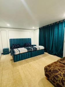 1 dormitorio con 2 camas y cortinas azules en Olive Ventures, Royal inn, Ritz, en Srinagar