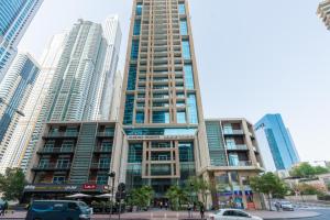 a tall building with cars parked in a city at Marina Heights Tower - Vigor Vacations Homes in Dubai