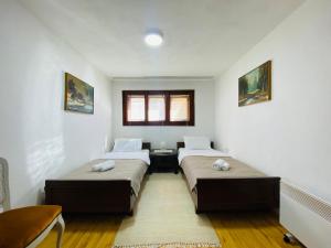 two beds in a room with white walls at Vintage Apartment in Skopje
