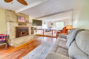 a living room with a couch and a fireplace at Elizabeth Vacation Rental with Private Hot Tub! in Elizabeth