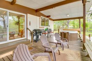 a screened porch with chairs and a table at Elizabeth Vacation Rental with Private Hot Tub! in Elizabeth