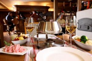 ein Tisch mit Tellern voller Speisen und Gläsern Wein in der Unterkunft Hotel Weinstube in Nendeln