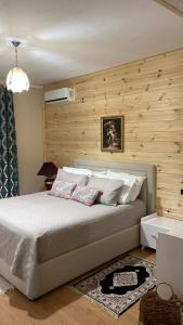 een slaapkamer met een bed met een houten muur bij Alva Room's in Gjirokastër