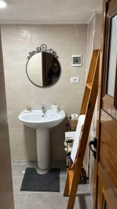 y baño con lavabo blanco y espejo. en Alva Room's en Gjirokastër
