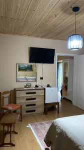 een slaapkamer met een bed en een tv aan de muur bij Alva Room's in Gjirokastër