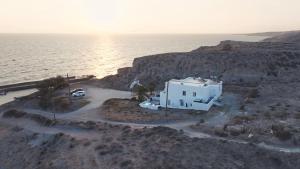 a white house on a cliff next to the ocean at Α Peaceful Seafront Escape in Santorini- Sonus Mare in Vourvoúlos