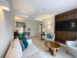 uma sala de estar com um sofá e uma televisão de ecrã plano em Four Points by Sheraton Sesimbra em Sesimbra