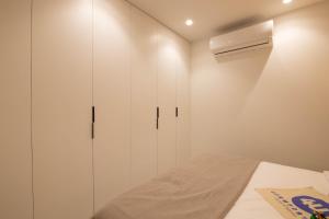 a white bedroom with a bed and a closet at Dorm4You Centro in Valencia