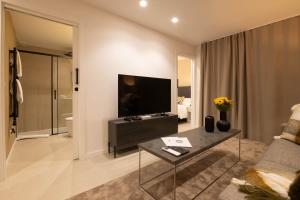 a living room with a flat screen tv and a couch at Dorm4You Centro in Valencia