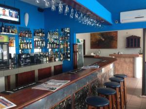 un bar con taburetes en una habitación con paredes azules en Acropole Hotel, en Cotonou