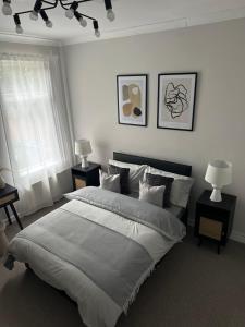 a white bedroom with a large bed with two lamps at Room in Manchester in Manchester
