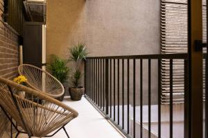 a balcony with a railing and two chairs and plants at Dorm4You Centro in Valencia
