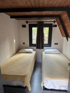 two beds in a room with a window at Arsuz Yunus Otel Bungalow in Arsuz