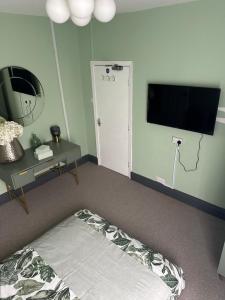 a bedroom with a bed and a flat screen tv at Room in Manchester in Manchester
