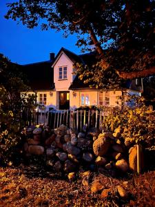 een huis met een hek en een berg stenen bij Ryttaretorpet in Vellinge