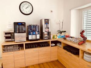 a kitchen with a clock on the wall above a counter at Hotel Garni Montaldi in Locarno