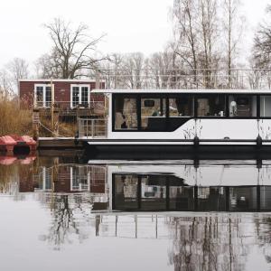 una casa en un barco en un cuerpo de agua en Hausboot-Tortuga, en Dömitz