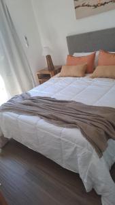 um quarto com uma grande cama branca com almofadas laranja em Alpine View Chalet Cafayate em Cafayate