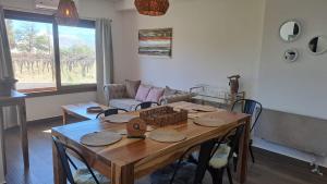 un soggiorno con tavolo in legno e sedie di Alpine View Chalet Cafayate a Cafayate