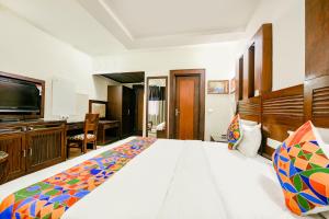 a bedroom with a large bed and a desk at FabHotel Grand Boutique in New Delhi +14 photos