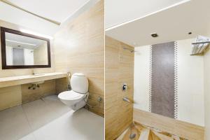a bathroom with a toilet and a sink and a mirror at FabHotel Grand Boutique in New Delhi