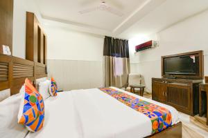 a hotel room with a bed and a flat screen tv at FabHotel Grand Boutique in New Delhi