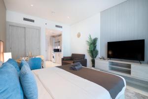 a bedroom with a large bed with a flat screen tv at Luxurious Studio at Palm Jumeirah in Dubai