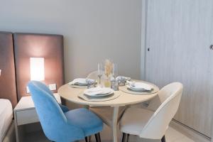 a dining room with a table and blue chairs at Luxurious Studio at Palm Jumeirah in Dubai