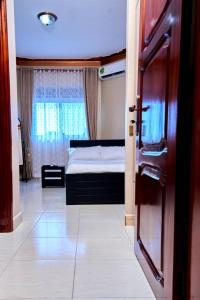 una camera con un letto e una porta con una finestra di PB & J Guest House Entebbe a Entebbe