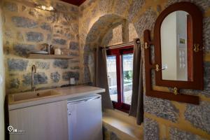 una cucina con lavandino, specchio e finestra di 'Panorama' Stone House On The Beach a Khalíkia