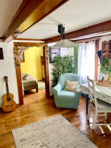 uma sala de estar com uma cadeira azul e uma guitarra em Private Room in an old Farmhouse near Vaduz em Sevelen