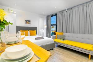 een hotelkamer met 2 bedden, een bank en een tafel bij City Studio - 3 Sleeps in Londen