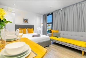 a hotel room with two beds and a couch and a table at City Studio - 3 Sleeps in London