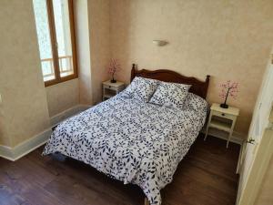 a bedroom with a bed with a black and white comforter at Le refuge des tanneurs in Tannay