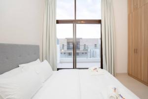een slaapkamer met een wit bed en een groot raam bij Zapbed Villa C62-03 in Dubai