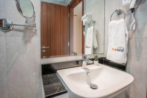 een badkamer met een witte wastafel en een spiegel bij Zapbed Villa C62-03 in Dubai