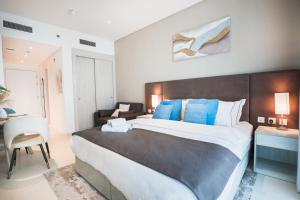 1 dormitorio con 1 cama grande con almohadas azules en Cosy Studio at Palm Jumeirah, en Dubái