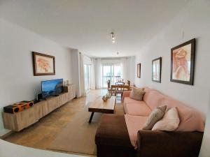 uma sala de estar com um sofá e uma televisão de ecrã plano em Seaview Puerta del Mar first line beach em Sitio de Calahonda
