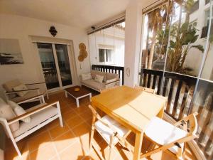 uma sala de estar com uma mesa e cadeiras numa varanda em Seaview Puerta del Mar first line beach em Sitio de Calahonda