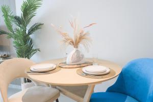 a dining room table with chairs and a vase with plants at Cosy Studio at Palm Jumeirah in Dubai