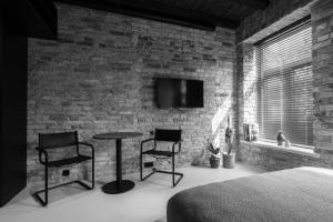 a bedroom with a brick wall and a table and chairs at Hortus Vilnius in Vilnius +25 photos