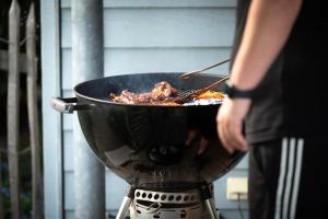 a person is cooking food in a pan on a grill at Ferienhaus Beim Viechdoktor in Crailsheim
